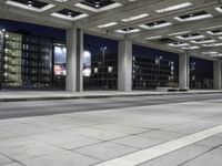 a person is sitting on the side walk looking at an empty street at night time