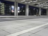 a person is sitting on the side walk looking at an empty street at night time