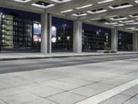 a person is sitting on the side walk looking at an empty street at night time