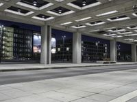 a person is sitting on the side walk looking at an empty street at night time