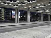 a person is sitting on the side walk looking at an empty street at night time