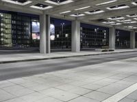 a person is sitting on the side walk looking at an empty street at night time