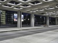 a person is sitting on the side walk looking at an empty street at night time