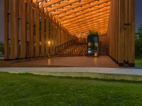 an outdoor seating space with an open door in a park under the trees at dusk