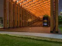 an outdoor seating space with an open door in a park under the trees at dusk