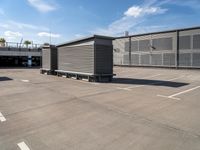 the empty parking lot at a storage unit for sale with metal sidinging and painted in white lines on the side