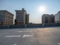 several large empty parking spaces in the city with buildings nearby in front of them -