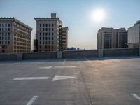 several large empty parking spaces in the city with buildings nearby in front of them -