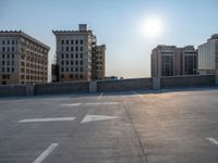 several large empty parking spaces in the city with buildings nearby in front of them -