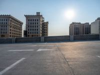 several large empty parking spaces in the city with buildings nearby in front of them -