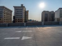 several large empty parking spaces in the city with buildings nearby in front of them -