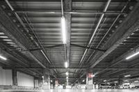 a garage with concrete floor and steel beams in black and white photo to depict urban urban spaces