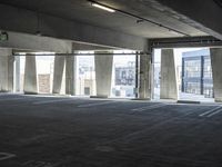 an empty parking garage with several rows of windows and chairs to the left of the door