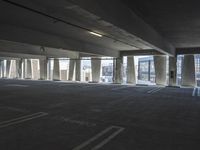 an empty parking garage with several rows of windows and chairs to the left of the door