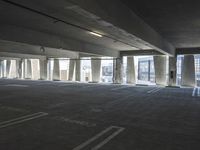 an empty parking garage with several rows of windows and chairs to the left of the door