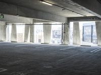 an empty parking garage with several rows of windows and chairs to the left of the door