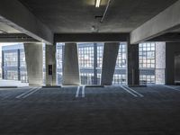 an empty parking garage with several rows of windows and chairs to the left of the door