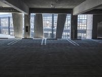 an empty parking garage with several rows of windows and chairs to the left of the door