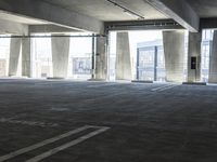 an empty parking garage with several rows of windows and chairs to the left of the door