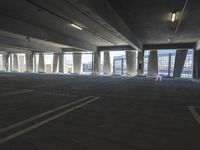 an empty parking garage with several rows of windows and chairs to the left of the door