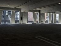 an empty parking garage with several rows of windows and chairs to the left of the door