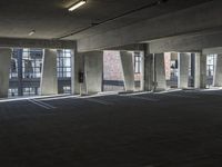 an empty parking garage with several rows of windows and chairs to the left of the door