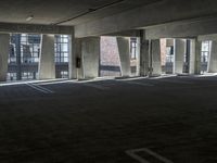 an empty parking garage with several rows of windows and chairs to the left of the door