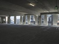 an empty parking garage with several rows of windows and chairs to the left of the door