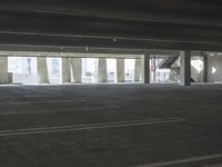 an empty parking garage with several rows of windows and chairs to the left of the door