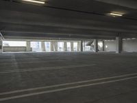 an empty parking garage with several rows of windows and chairs to the left of the door