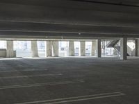 an empty parking garage with several rows of windows and chairs to the left of the door