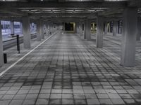 a large empty parking garage with a black and white photo of the interior area, a few chairs and benches