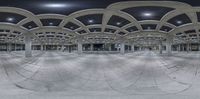 a panoramic view of a parking garage with columns and arches at night with a red fire hydrant