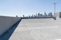 an empty parking lot with a view of a city in the background and blue sky