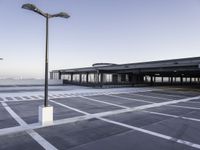 the empty parking lot at the airport with a long pole in it's center