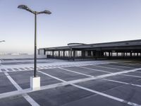 the empty parking lot at the airport with a long pole in it's center