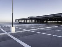 the empty parking lot at the airport with a long pole in it's center