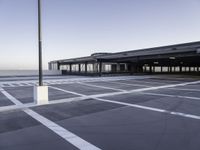 the empty parking lot at the airport with a long pole in it's center