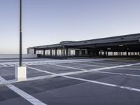 the empty parking lot at the airport with a long pole in it's center