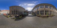 fish eye view looking at a parking lot in a city with buildings and benches on the right