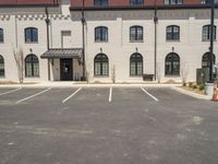 a small parking lot with a fire hydrant and some buildings with windows and pillars on it