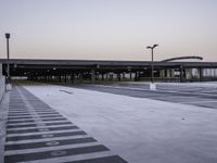 an empty parking lot is shown as the sun sets over it and there are no cars in front