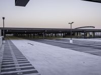 an empty parking lot is shown as the sun sets over it and there are no cars in front