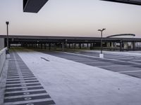 an empty parking lot is shown as the sun sets over it and there are no cars in front