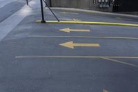 two yellow arrows pointing left into an underground parking lot in the city side street,