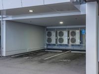 a parking garage with a row of heating units and an enclosed area between the entrance