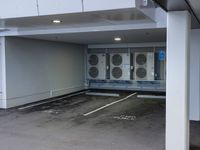 a parking garage with a row of heating units and an enclosed area between the entrance