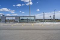 a large parking lot with several parking spaces around it and a sky with some clouds