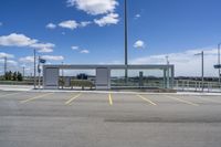 a large parking lot with several parking spaces around it and a sky with some clouds