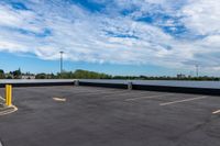 a parking lot with many storage containers under a cloudy blue sky by the docks area